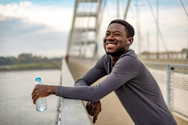 istock Handsome young man standing and holding a water bottle before working out. 1818083901