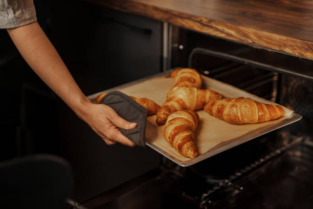 freshly baked croissants taken out of oven - golden algae imagens e fotografias de stock