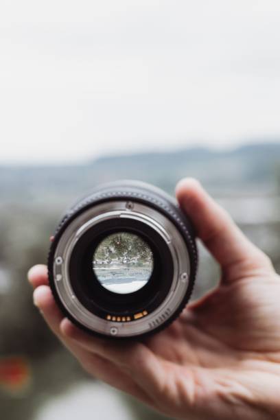 istock Person holding a camera lens in their hands, examining it closely. 1818168002