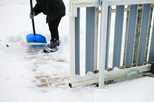 a worker removes snow around a sliding gate
