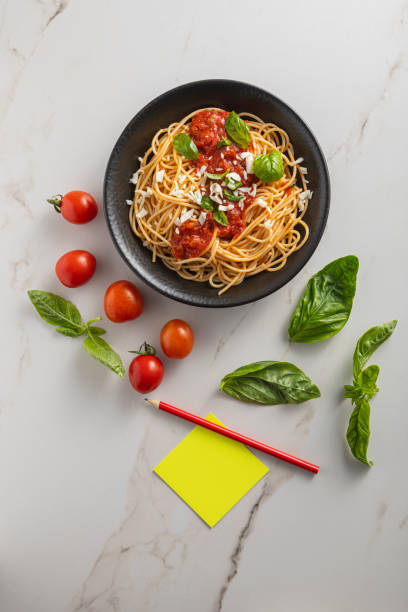 Pasta, spaghetti with tomato sauce in black bowl