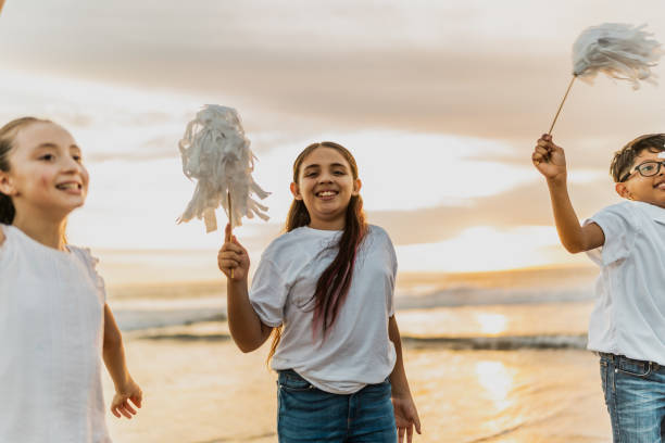 портрет детской девочки, играющей в помпон со своими друзьями на пляже - community outreach child social worker waist up стоковые фото и изображения
