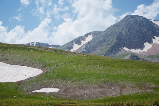 Summer mountain landscape with places of lying snow that has not lost.