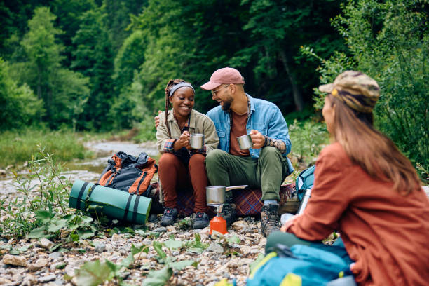 istock Cheerful group of hikers drinking tea and talking in the woods. 1818221184