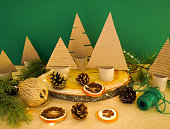 A creative handmade little Christmas tree of cardboard on green backround. eco-friendly and zero waste concept