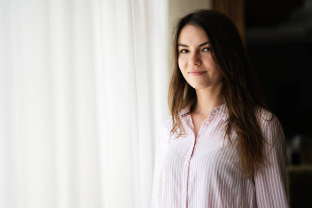 istock Young beautiful brunette woman at the window light background. 1818237898