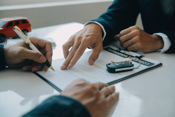 un vendedor de automóviles o gerente de ventas de hombres asiáticos de primer plano ofrece vender un automóvil y explica y lee los términos de la firma de un contrato y seguro de automóvil. - car insurance sales occupation buying fotografías e imágenes de stock