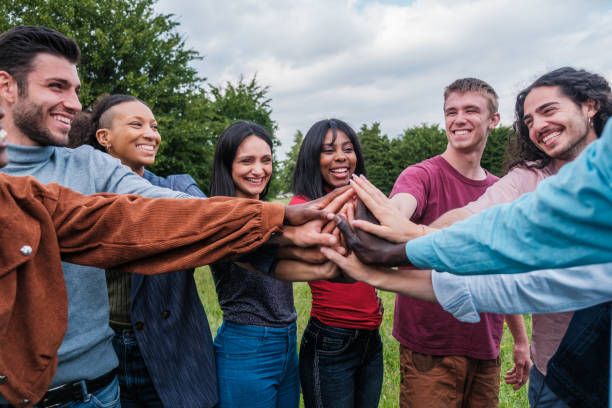 istock Group of young people joining hands to join forces and work as a team 1818253586
