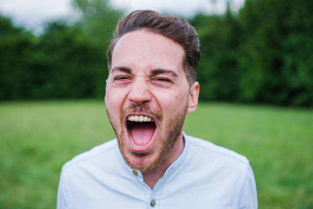 istock Young blond hair man screaming outdoors in the park 1818254633
