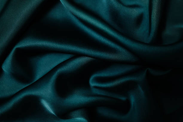 istock Emerald green silk or satin, draped fabric, elegant background.  Beautiful wavy space for design Close-up images are blurry or blurred. 1818255736