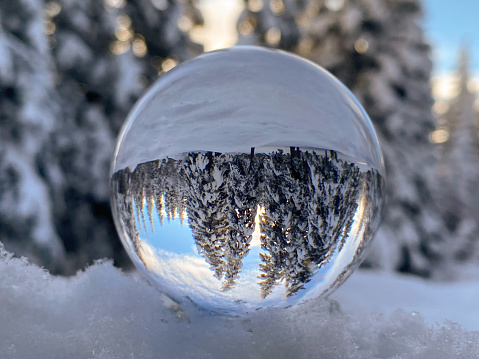 The beauty of a winter scene is reflected in a crystal ball. Alaska’s winter snow makes for stunning photo opportunities.