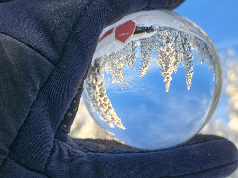 The beauty of a winter scene is reflected in a crystal ball. Alaska’s winter snow makes for stunning photo opportunities.