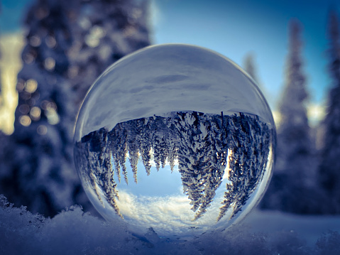 The beauty of a winter scene is reflected in a crystal ball. Alaska’s winter snow makes for stunning photo opportunities.