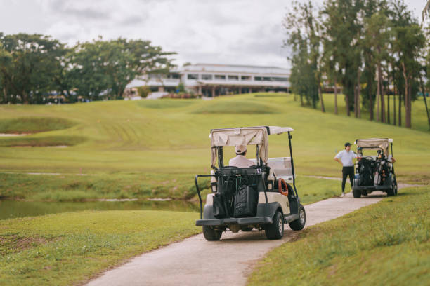 ゴルフコースの週末の朝にゴルフカートを運転するアジアの中国人ゴルファー - golf cart golf bag horizontal outdoors ストックフォトと画像
