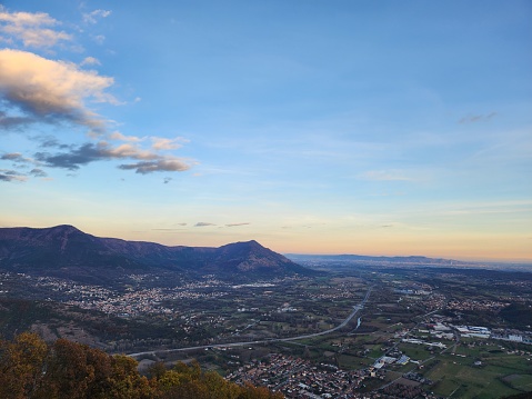 An aerial view on the valley, with the mountains, the town and the sunset