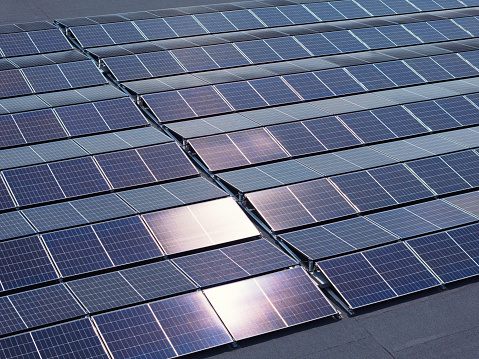 A new solar panel installation on the roof of a large industrial building.