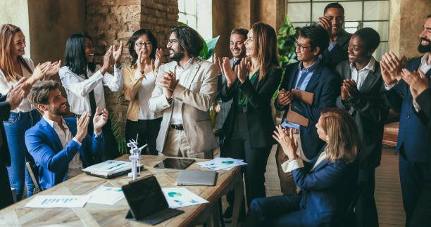 istock Multigenerational colleagues clapping hands for a succesful green energy project inside business modern office - Teamwork greeting each others for environmental deal - Soft focus on center woman face 1818294960
