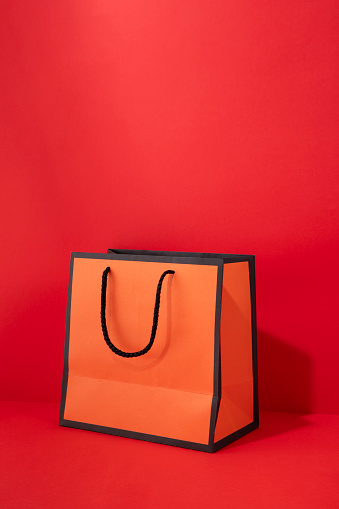 Shopping bag on red background with copy space