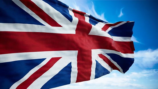 Waving flag of the UK against the sky background.