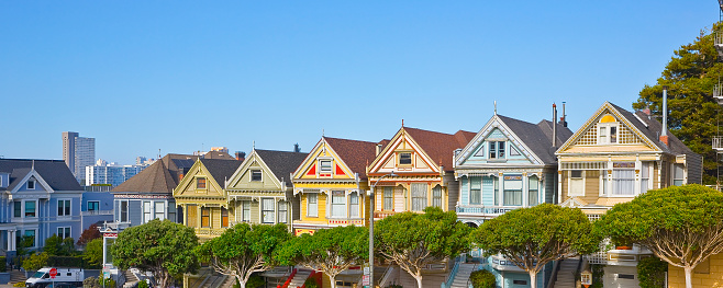 Low angle view of a victorian home with turret wall against the clear sky at San Francisco, CA. Home exterior with decorative frieze board and scalloped shingle siding on the turret.