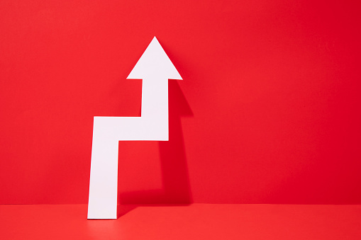 Growth concept with paper arrow on red background