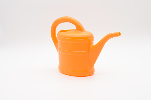 Orange watering can from the side, isolated on a white background
