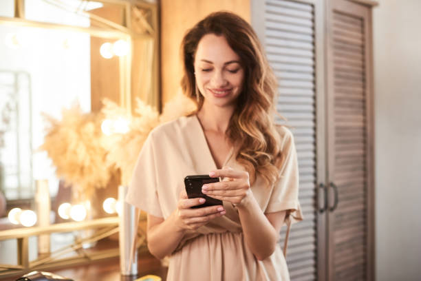istock defocus woman beauty salon using cellphone for giving feedback online. Selected focus on hands 1818318501