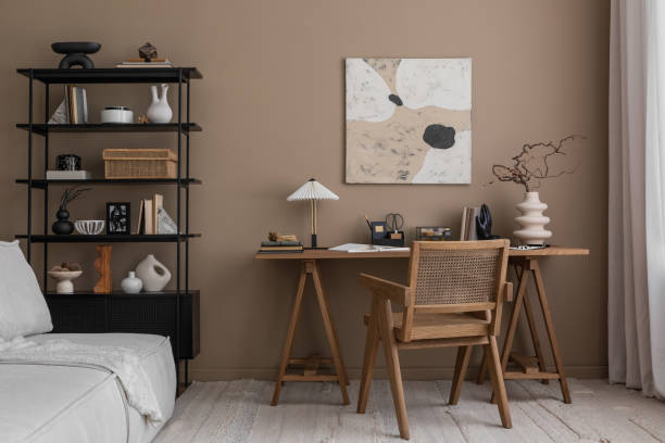 istock Interior design of aesthetic composition of workspace interior with mock up poster frame, wooden desk, rattan chair, modular sofa, stylish lamp and personal accessories. Home decor. Template. 1818325743