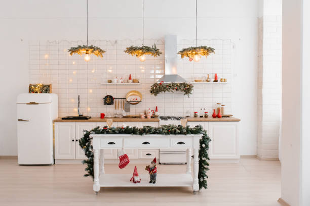 istock Christmas white Scandinavian kitchen interior with red decor and lights. Island table in the middle of the kitchen 1818325769