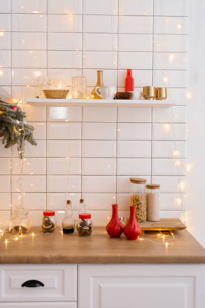 istock Kitchenware and decor on a white shelf in a cozy kitchen with lights. Christmas home decoration 1818325770