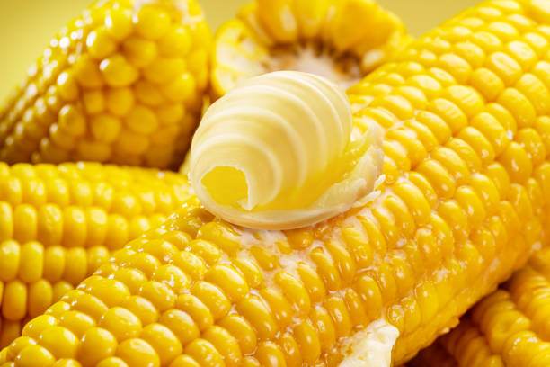 istock Ripe corn heads with corn whiskers and leaves. Nice vegetable cooking background for your projects. 1818326900
