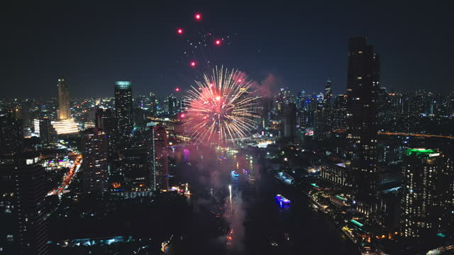4K Footage Aerial drone point of view Multi colors Fireworks Displays over the Cityscape and Skyscraper Celebrate Night Lights, river and Bangkok bridge
