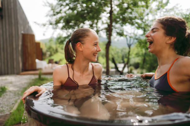 Two young women taking an ice cold bath Photo of two young women having a spa day in the cabin in the woods; They are taking an ice bath after using the sauna just do it stock pictures, royalty-free photos & images
