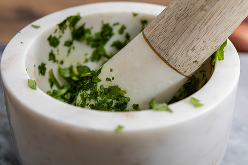 Close up of Mortar and Pestle crushing Coriander