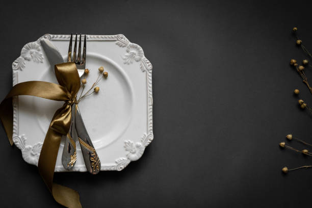 istock Romantic tabble setting with ribbon, plates, cutlery on black background. Empty plate. Mockup design layout for your text. Love romantic concept. Copy space. Top view. Flat lay. 1818354543