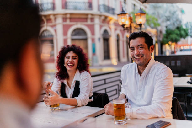 istock Coworkers talking while drinking beer on happy hour at bar 1818356158