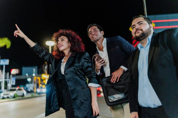 istock Coworkers hailing a cab while talking on mobile phone at street 1818385970