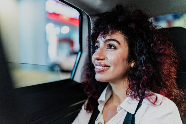 istock Young businesswoman contemplating while looking through the cab window 1818390854