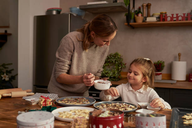 istock Mother and daughter decorating gingerbreads with chocolate 1818405537