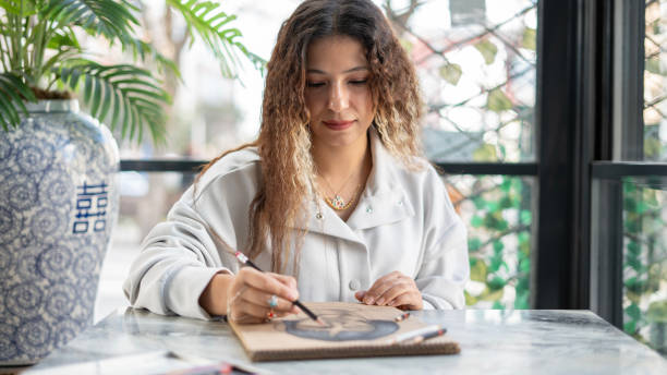 istock Beautiful woman smiling and making a pencil drawing 1818415161