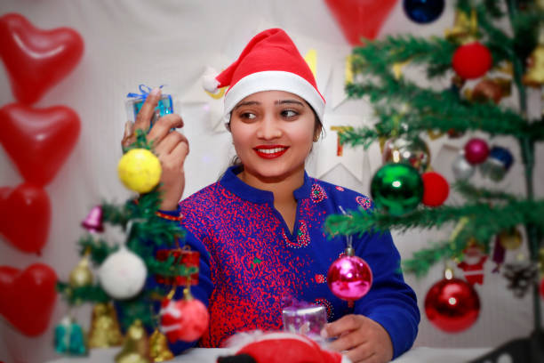 istock Young woman decorating the Christmas tree at home 1818416842