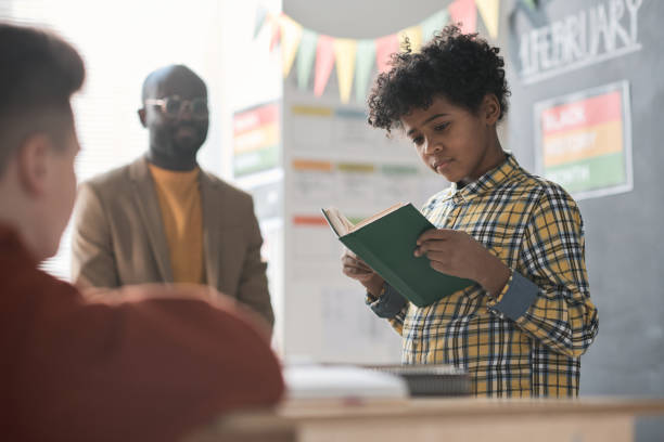 istock Schoolboy reading a book at lesson 1818417914