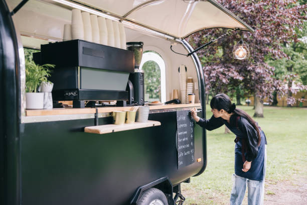 Japanese barista writing the menu on her coffee trailer stock photo