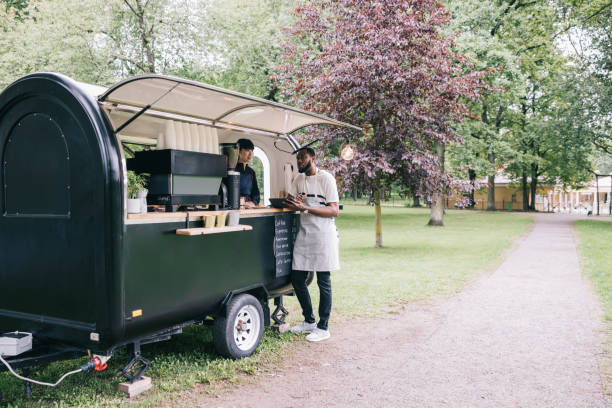 istock Two coffee trailer baristas, using digital tablet together 1818422052