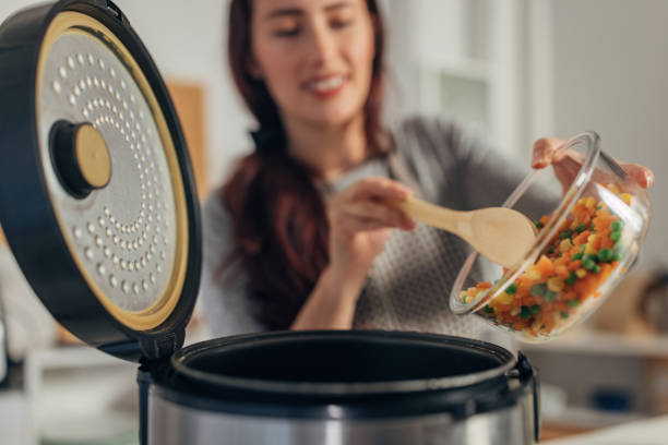 istock Hispanic woman using slow cooker while preparing food in the kitchen 1818446362