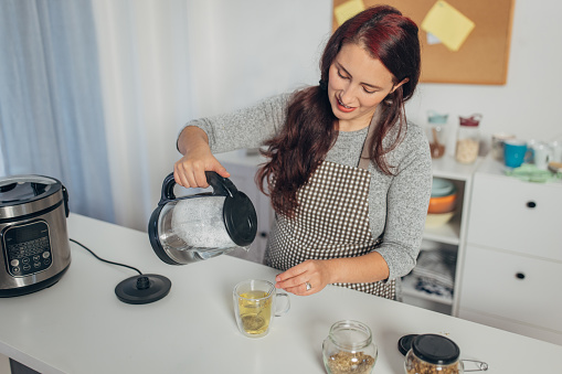 Hispanic woman boiling water in the kettle