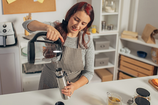 Hispanic woman boiling water in the kettle