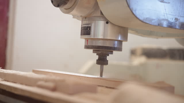 CNC machine makes cut in wooden board in furniture factory