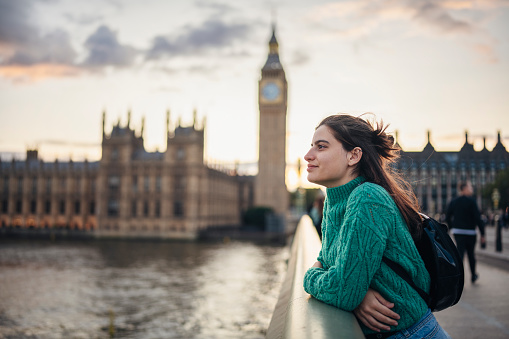 Young female tourist admiring the beauty of city of London on the Westminster bridge next to Big Ben.London,UK.