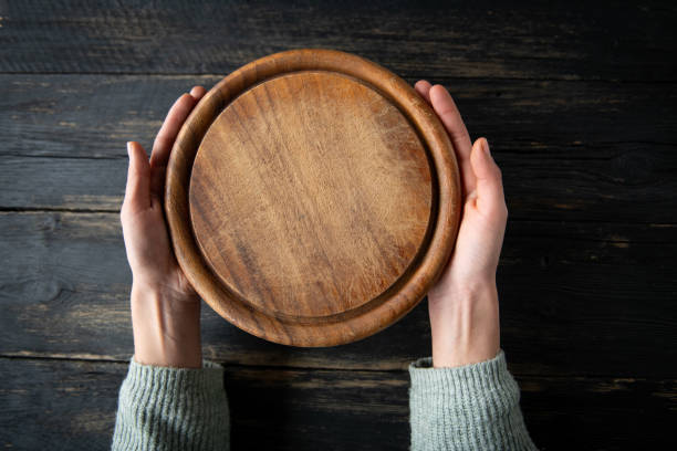 istock Pizza cutting board at rustic wooden table in hands 1818462823